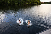 Brothers jumping into lake