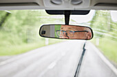 Reflection of senior man in rear-view mirror