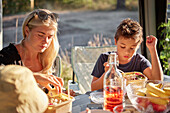 Mother and daughter having meal outdoors