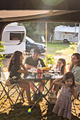 Familie beim Essen auf dem Campingplatz
