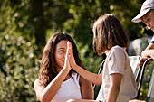 Teenage girl giving her sister high five