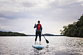 Woman paddle boarding on river