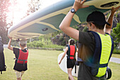Children carrying paddle board