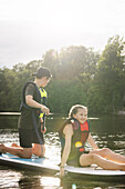 Brother and sister paddle boarding