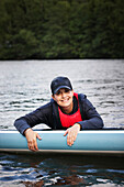 Porträt einer Frau beim Paddelboarding auf einem See