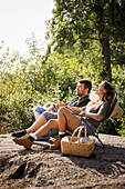 Couple sunbathing on lounge chairs