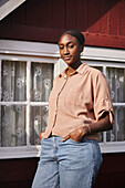 Woman standing in front of wooden house