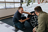 Salesman and male customer in car dealership