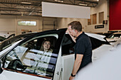 Salesman and female customer in car dealership