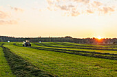 Traktor auf dem Feld bei Sonnenuntergang