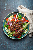Grilled beef kebabs served with fresh vegetables salad (Traditional Middle Eastern and Turkish dish)