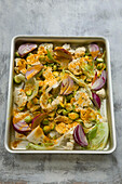 Cauliflower florets with red onions and turmeric in a roasting tin