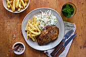 Roasted pork steak with french fries and cold slaw