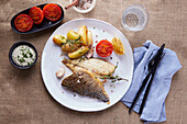Fried gilthead with potatoes and tomatoes