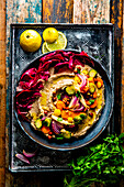 Loaded hummus with winter vegetables and walnuts