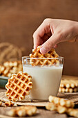 Hand dipping a mini waffle in milk