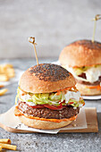 Burger mit Tomaten, Salat und Stracciatella-Käse