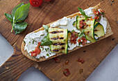 Baguette with cream cheese, grilled zucchini slices and basil