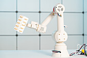 Robotic arm holding blisterpack of tablets