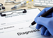Doctor filling out a diagnosis form, conceptual image