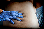 Doctor examining a patient's abdomen, conceptual image