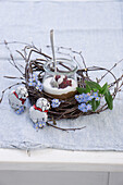 Chocolate mousse with cream and currants in a jar, with birch wreath, forget-me-not and chocolate lambs