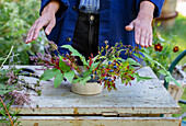Autumn flower arrangement with heather, raspberry branch and blueberries