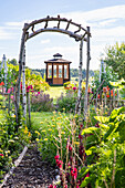 Vegetable garden with trellis, pavilion in the garden in the background