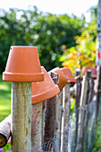 Fence of branches decorated with terracotta pots