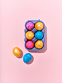 Top view layout with colored easter eggs on pink background