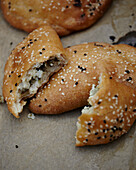 Seeded pastry pies filled with cheese and parsley