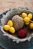 Zimtapfel, gelbe Litschis und Rambutan in Vintage-Schüssel