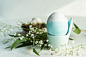 Blau gefärbtes Ei im Eierbecher zu Ostern