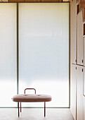 Leather stool in front of insulating glass wall and built in elements