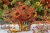 Herbststrauß aus Sonnenblumen und Hagebuttenzweigen