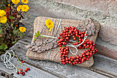 Gifts wrapped in burlap decorated with tree bark and a rose hip heart shaped wreath