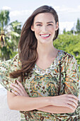 A young woman wearing a colorful, airy summer blouse