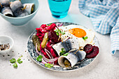Labskaus with gherkins, rollmops and fried egg