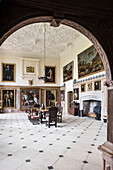 View through decorative wooden archway to restored banquet hall with high ceiling