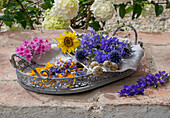 Summer flowers and poppy seedpods on nostalgic tray