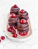 Chocolate cupcakes with chocolate ganache and cherries