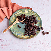 Raisins with wooden spoon on plate