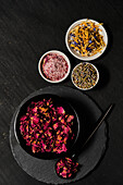 Rose blossoms in black bowl, lavender blossoms, blossom salt and blossom mix in white bowls