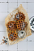 Spicy pumpkin waffles with fresh blueberries and dusted with powdered sugar