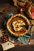 Pumpkin pie with whipped cream, pecans, orange zest, and honey