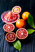 Blood oranges, whole and halved with juicer and reamer