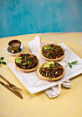 Warm glass noodle salad with beech mushrooms, soy snails and avocado in shortbread bowls, vegan