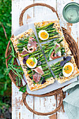 Puff pastry tart with green asparagus, prosciutto and egg