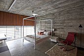 Bedroom with wall of windows and exposed concrete