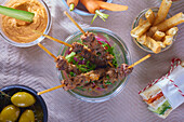 Lamb skewers with various side dishes in set for a picnic